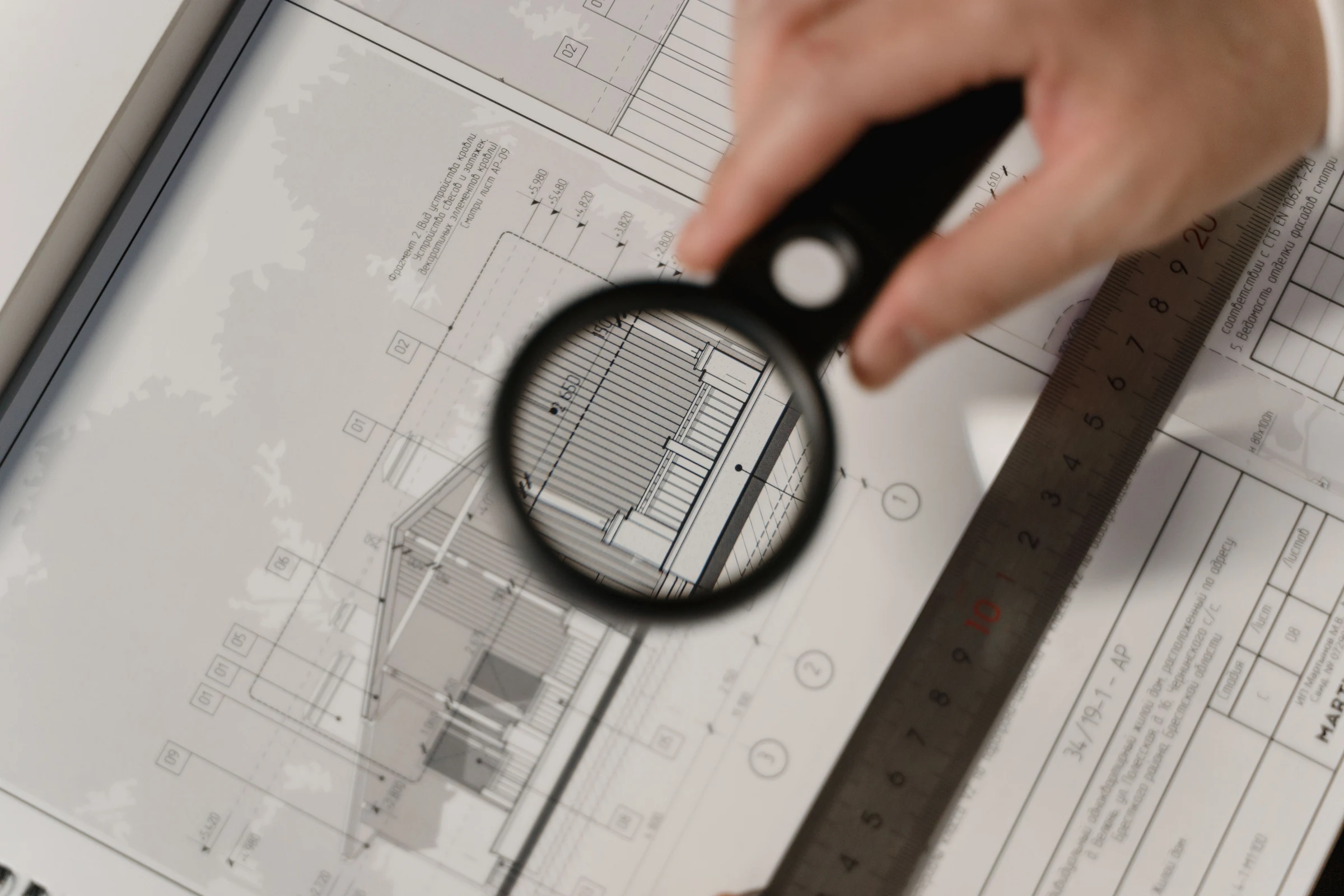 Architectural plans being reviewed with a magnifying glass